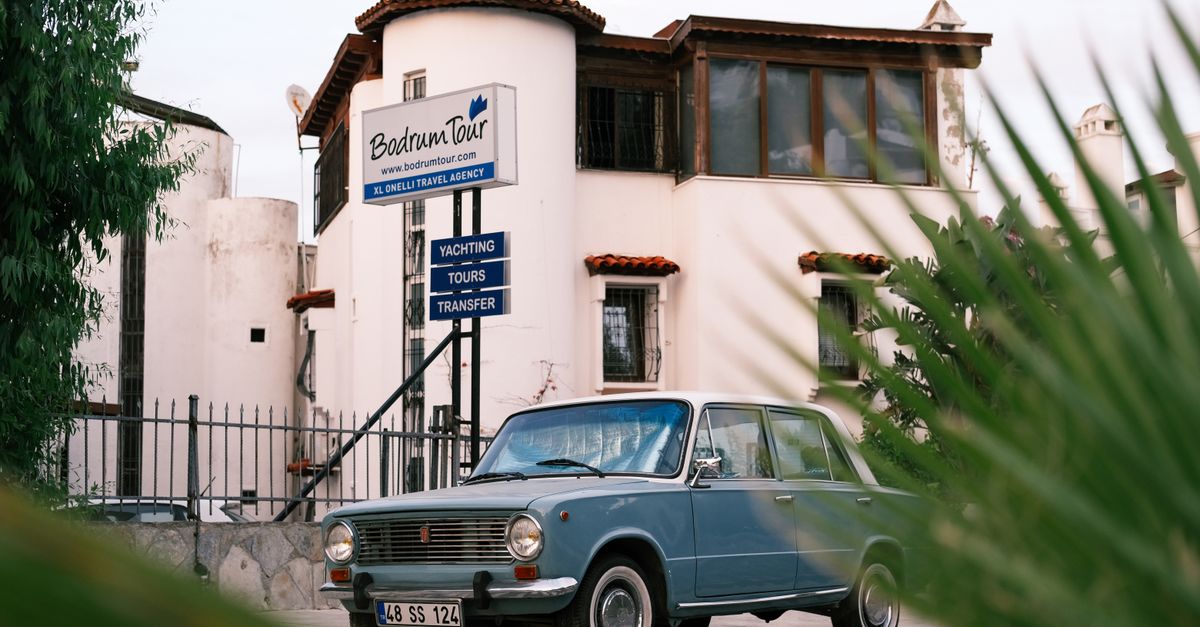 Classic car parked near Bodrum Tour Agency, showcasing retro automotive style.